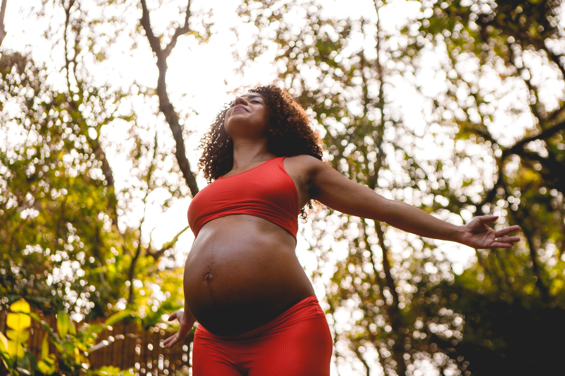 an image of a pregnant woman in a red sports bra